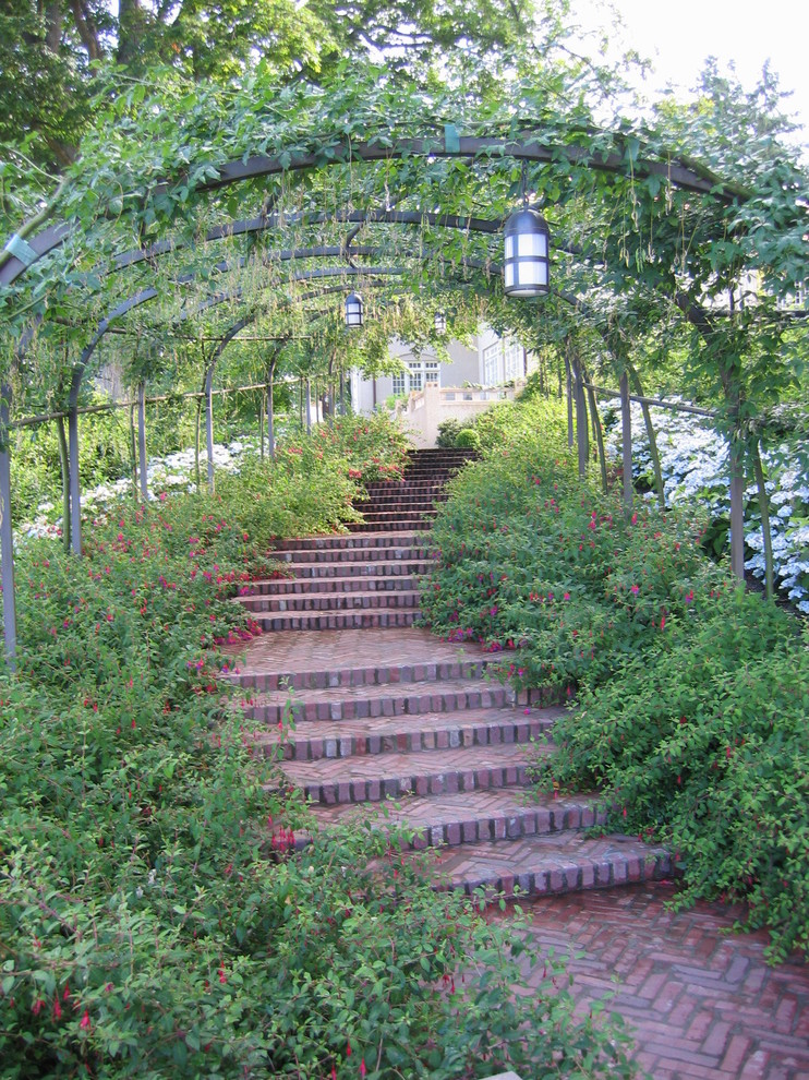 Foto di un grande giardino tradizionale con un ingresso o sentiero, un pendio, una collina o una riva e pavimentazioni in mattoni
