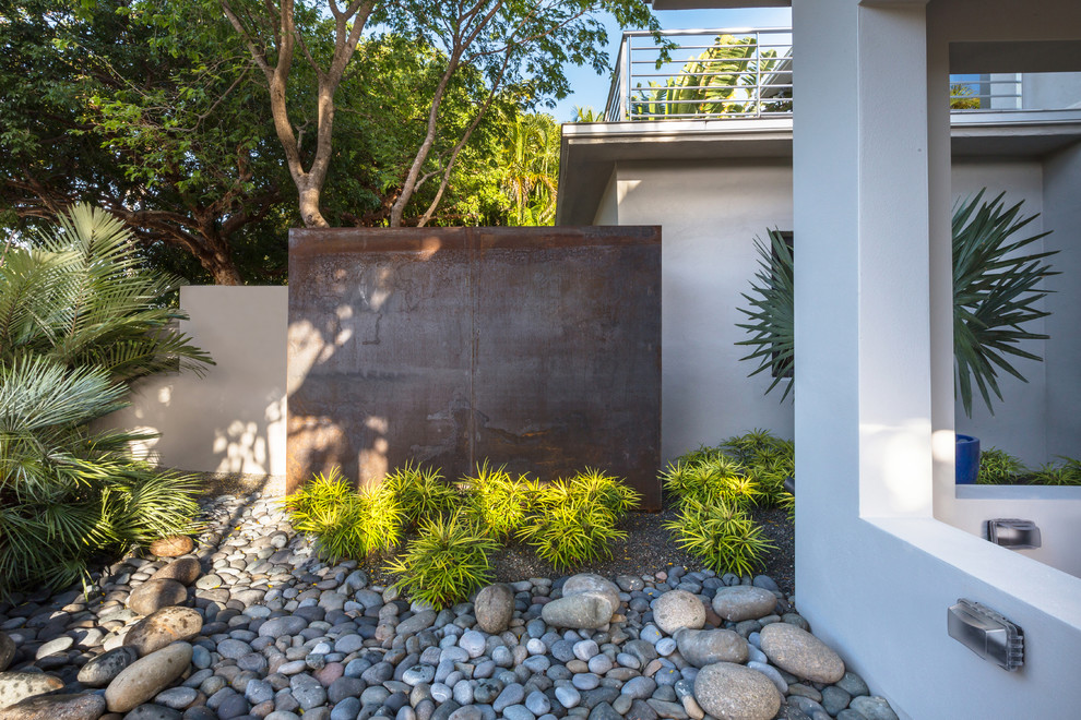 This is an example of a medium sized contemporary side partial sun garden in Miami.