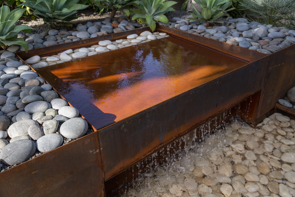 Design ideas for a contemporary side partial sun garden in Miami with a water feature.