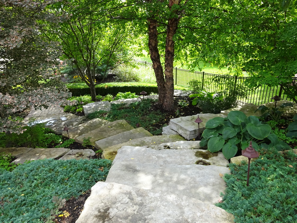 Idéer för en stor klassisk trädgård i slänt, med en vertikal trädgård och naturstensplattor