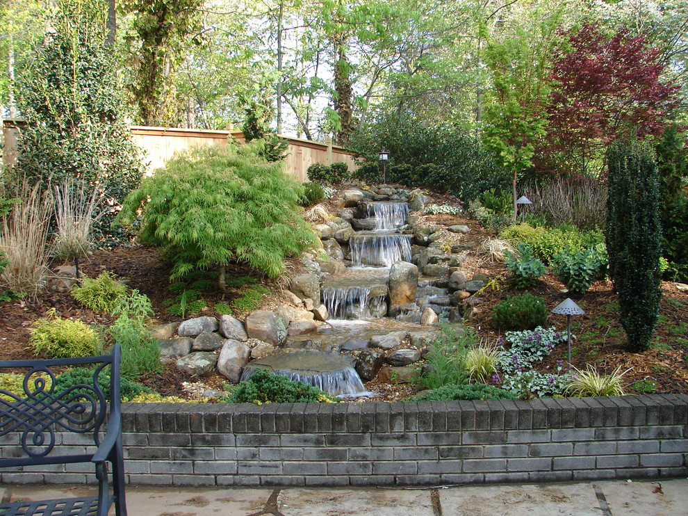 Foto di un giardino formale chic esposto in pieno sole di medie dimensioni e dietro casa in primavera con fontane e pavimentazioni in pietra naturale