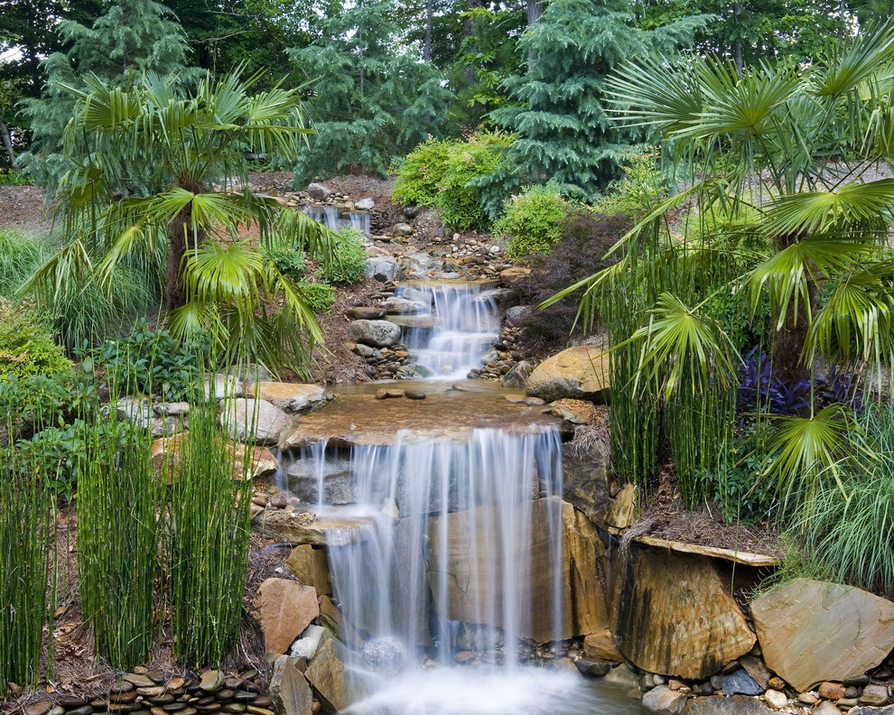 Aménagement d'un jardin à la française arrière classique de taille moyenne et l'automne avec un point d'eau, une exposition partiellement ombragée et des pavés en pierre naturelle.