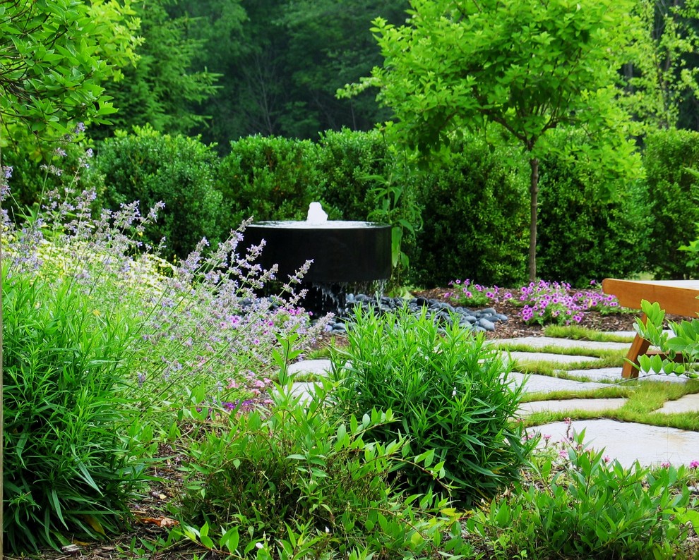 Immagine di un grande giardino tradizionale esposto a mezz'ombra dietro casa in estate con fontane e pavimentazioni in pietra naturale