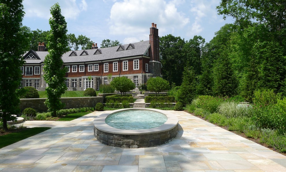 Immagine di un ampio giardino chic esposto in pieno sole nel cortile laterale in estate con fontane e pavimentazioni in pietra naturale