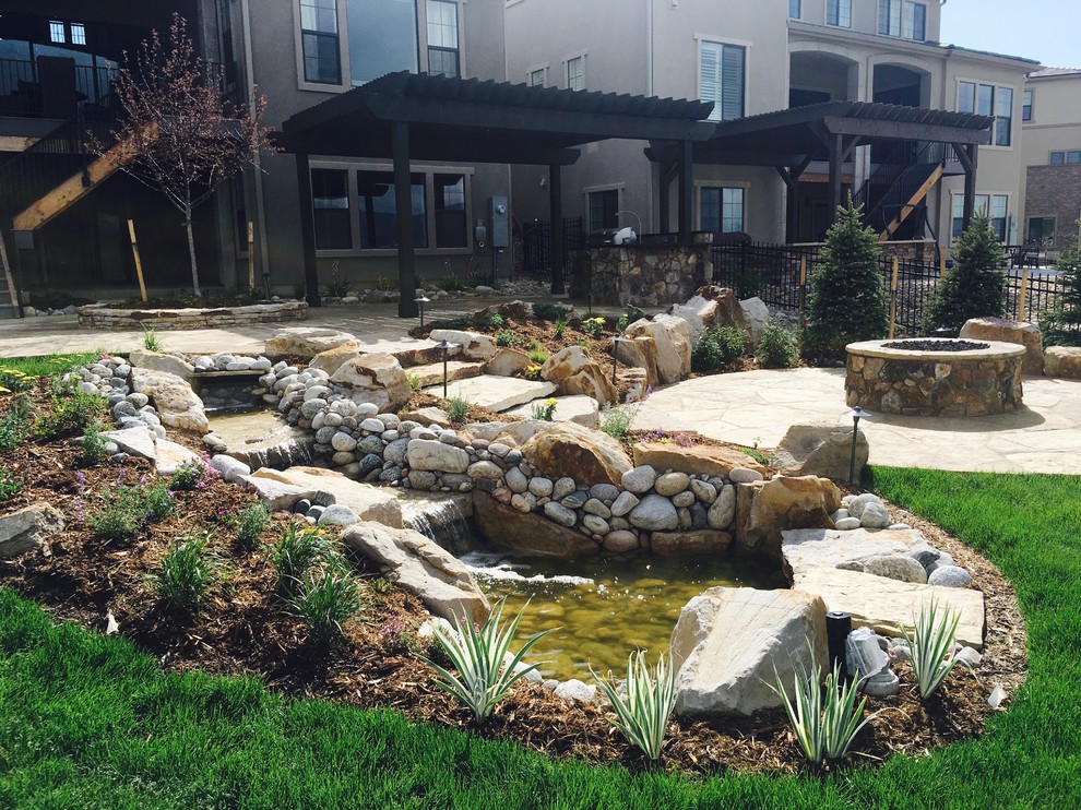 Photo of a large rustic drought-tolerant and full sun backyard stone pond in Denver for summer.