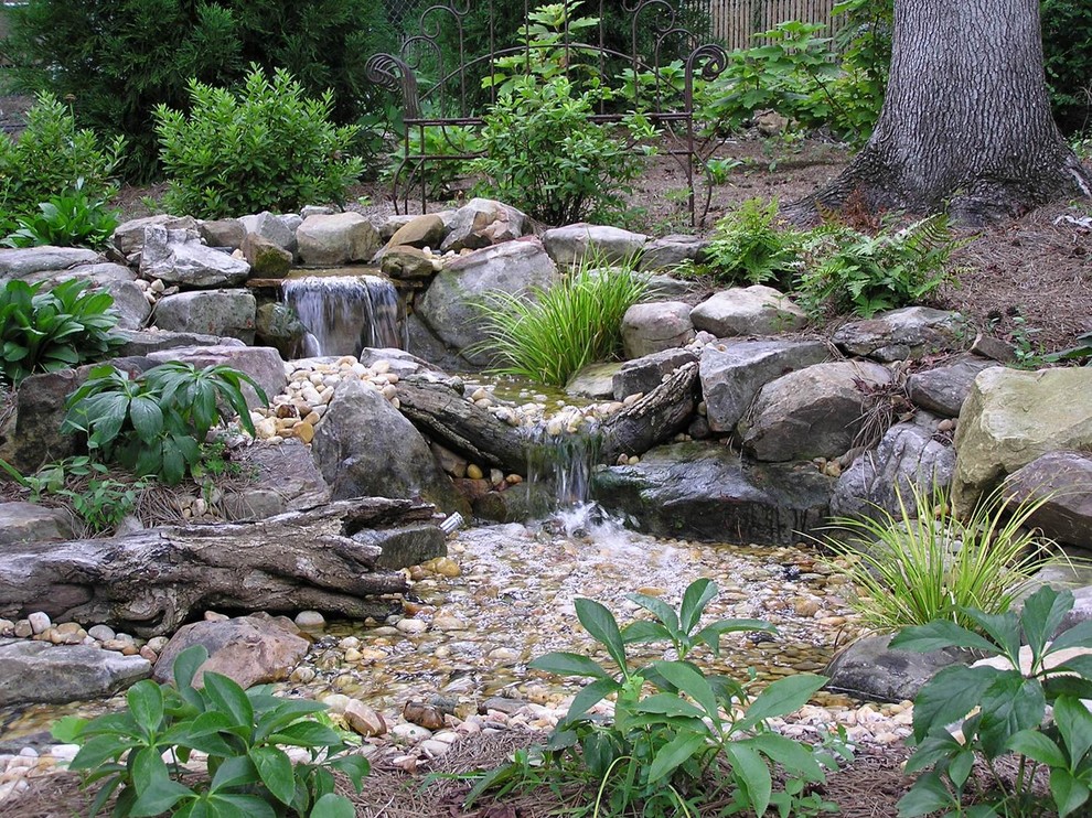 Esempio di un laghetto da giardino rustico esposto in pieno sole di medie dimensioni e dietro casa in estate con pavimentazioni in pietra naturale