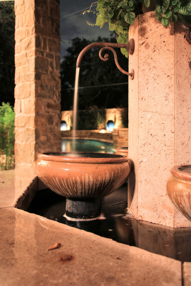 Esempio di un giardino mediterraneo esposto in pieno sole di medie dimensioni e dietro casa in estate con fontane e pavimentazioni in pietra naturale