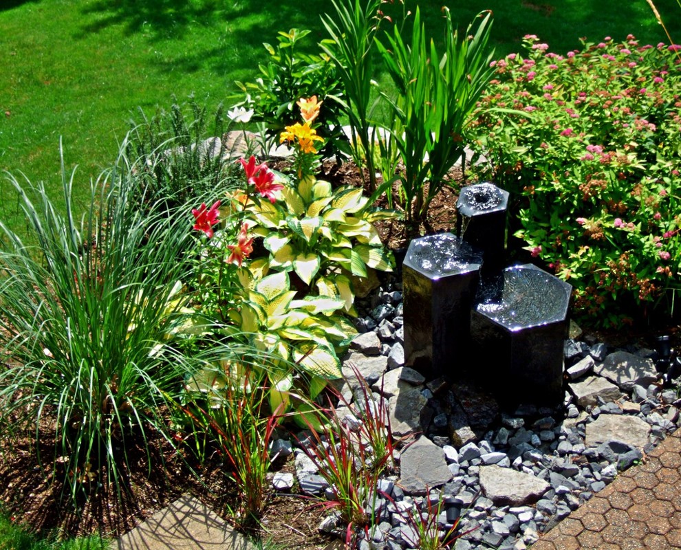 Modelo de jardín contemporáneo en patio trasero con cascada y piedra decorativa