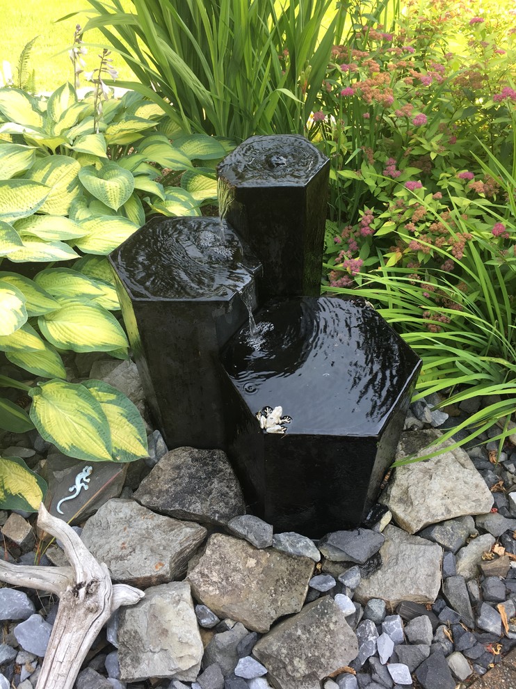 Ispirazione per un giardino minimalista dietro casa con fontane e sassi di fiume