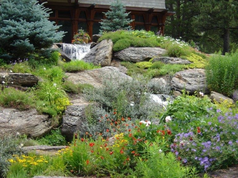 На фото: большой солнечный садовый фонтан на склоне в стиле рустика с хорошей освещенностью и покрытием из каменной брусчатки