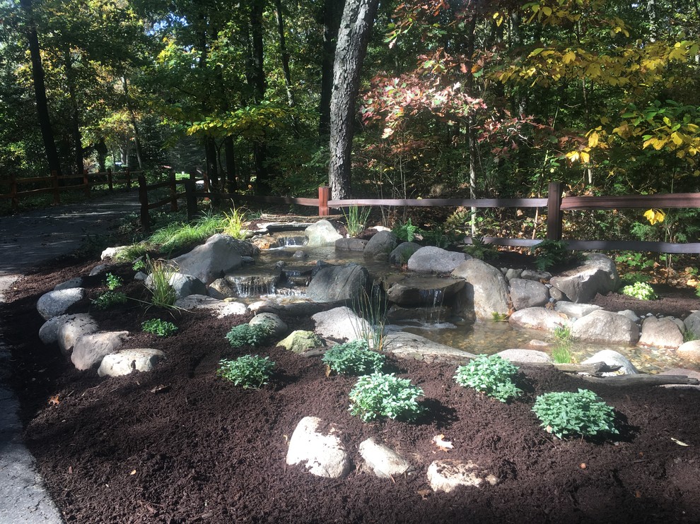 На фото: маленький тенистый, летний садовый фонтан на боковом дворе в классическом стиле с подъездной дорогой и мульчированием для на участке и в саду