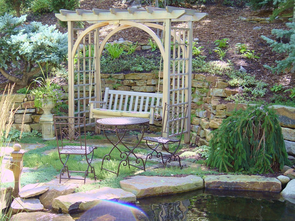Réalisation d'un jardin à la française arrière champêtre de taille moyenne et l'été avec un point d'eau, une exposition partiellement ombragée et des pavés en pierre naturelle.