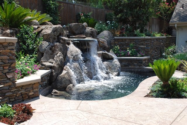 Esempio di un ampio giardino stile americano esposto in pieno sole dietro casa in estate con fontane e pavimentazioni in pietra naturale