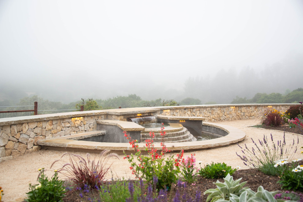 Idée de décoration pour un grand jardin arrière tradition avec un point d'eau, une exposition ensoleillée et des pavés en pierre naturelle.