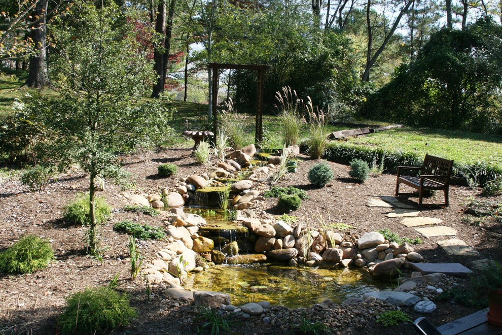 Bild på en stor vintage bakgård, med en fontän och naturstensplattor