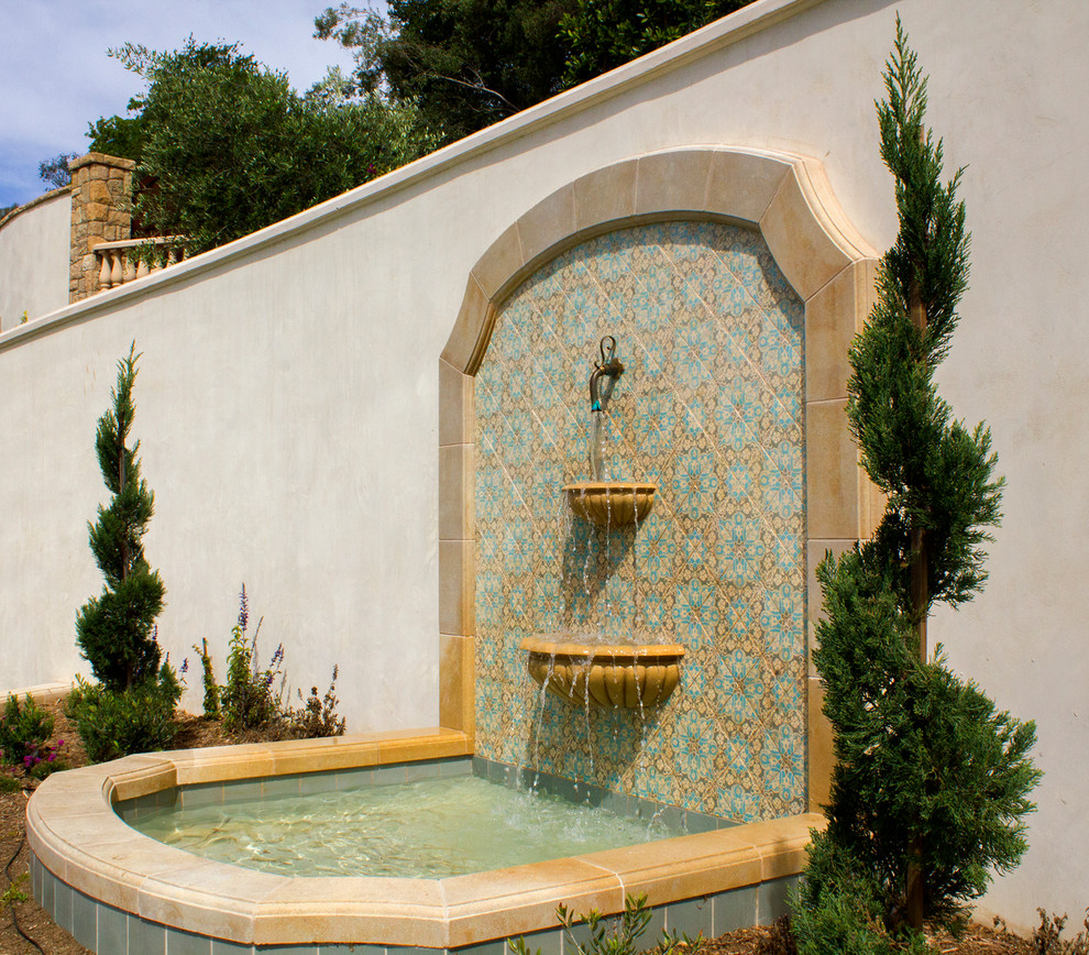 Esempio di un giardino formale esposto in pieno sole di medie dimensioni e dietro casa in estate con fontane e pavimentazioni in mattoni