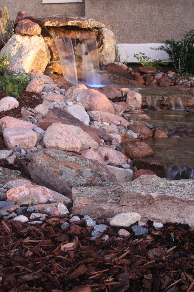 Inspiration for a large rustic back formal partial sun garden for summer in Denver with natural stone paving and a pond.
