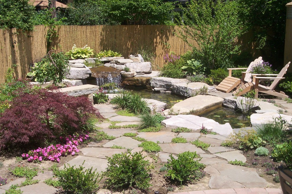 Photo of a contemporary garden in Detroit with a water feature.