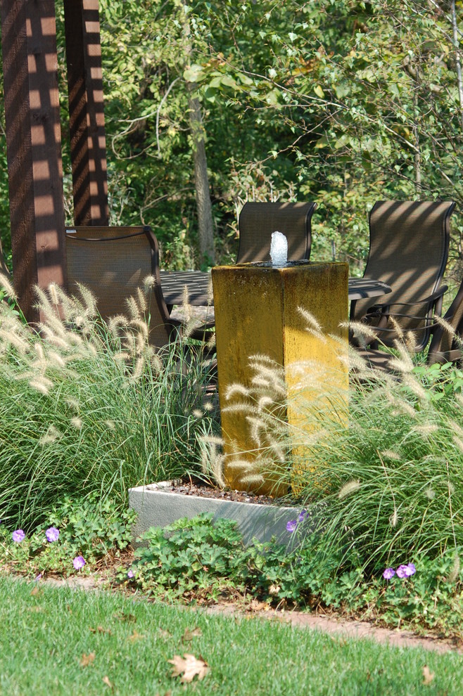 На фото: садовый фонтан на заднем дворе в классическом стиле