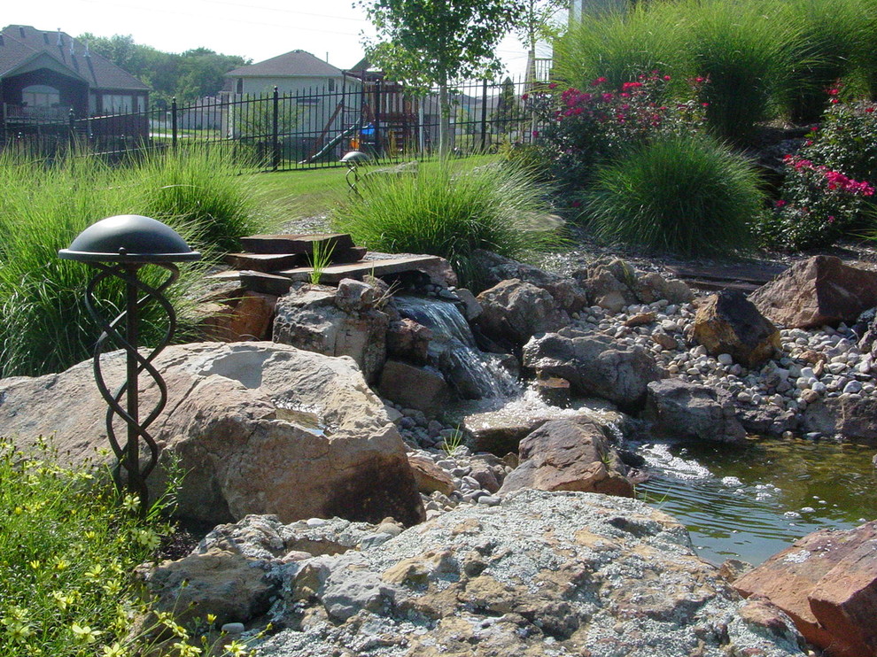 Exempel på en stor klassisk bakgård i delvis sol på sommaren, med en fontän