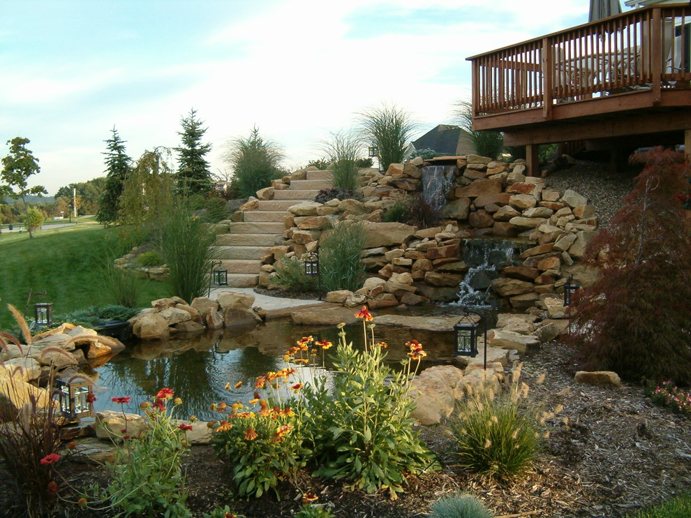 Immagine di un laghetto da giardino chic esposto in pieno sole di medie dimensioni e dietro casa con pavimentazioni in pietra naturale