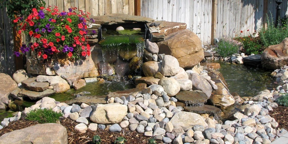 Kleiner, Halbschattiger Klassischer Garten im Sommer, hinter dem Haus mit Wasserspiel und Natursteinplatten in Salt Lake City