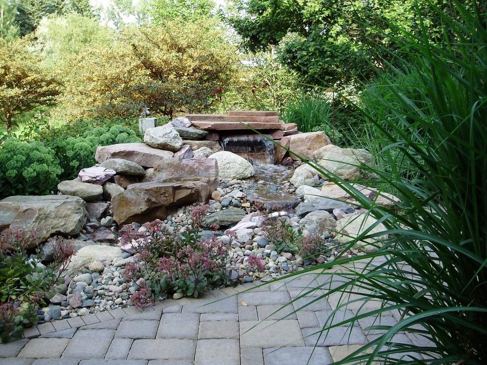 Idée de décoration pour un jardin arrière tradition l'été et de taille moyenne avec une exposition ensoleillée, des pavés en béton et un bassin.