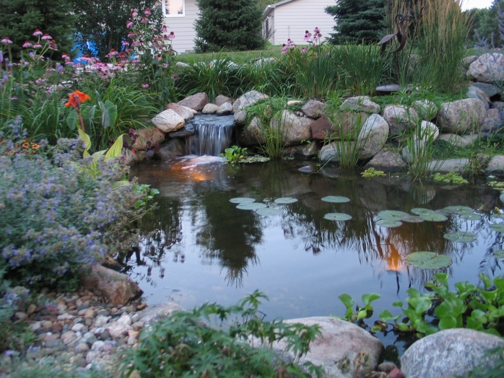 Aménagement d'un jardin classique de taille moyenne et l'été avec un bassin, une exposition partiellement ombragée et un paillis.