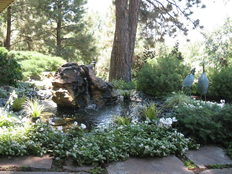 Medium sized world-inspired front fully shaded garden in Denver with a water feature and natural stone paving.