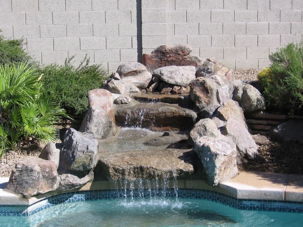 Ejemplo de jardín de estilo americano pequeño en patio trasero con fuente