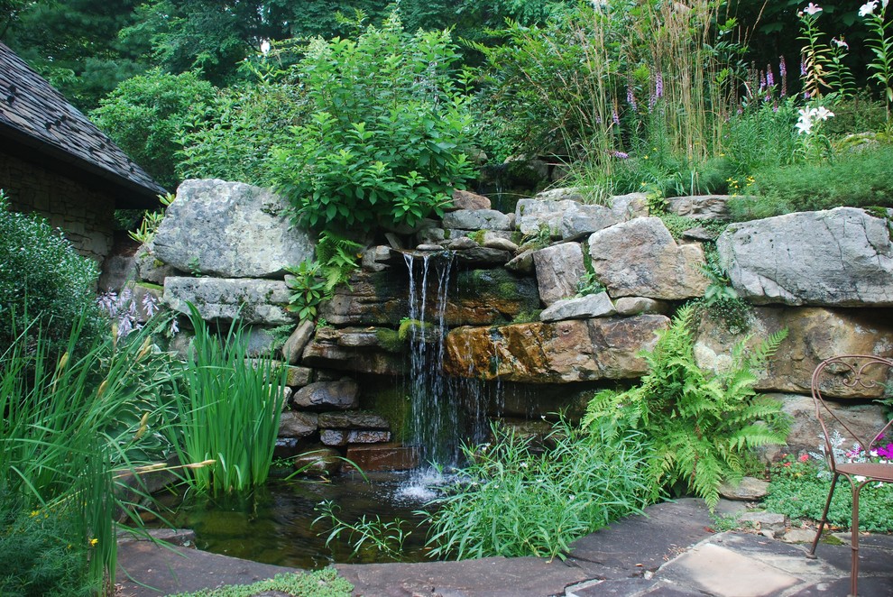 Rustic garden in Other with a water feature.