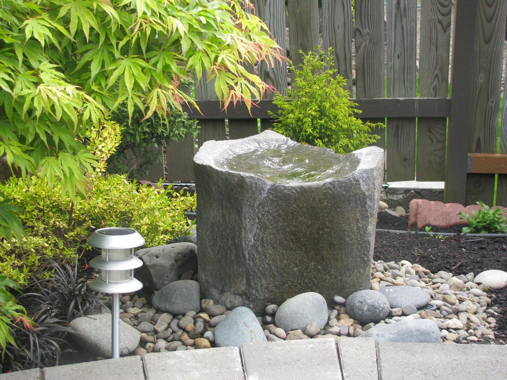 Immagine di un piccolo giardino design dietro casa con fontane