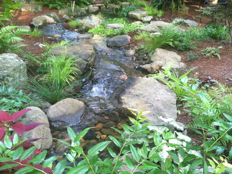 Photo of a medium sized classic partial sun garden in Orange County with mulch and a pond.