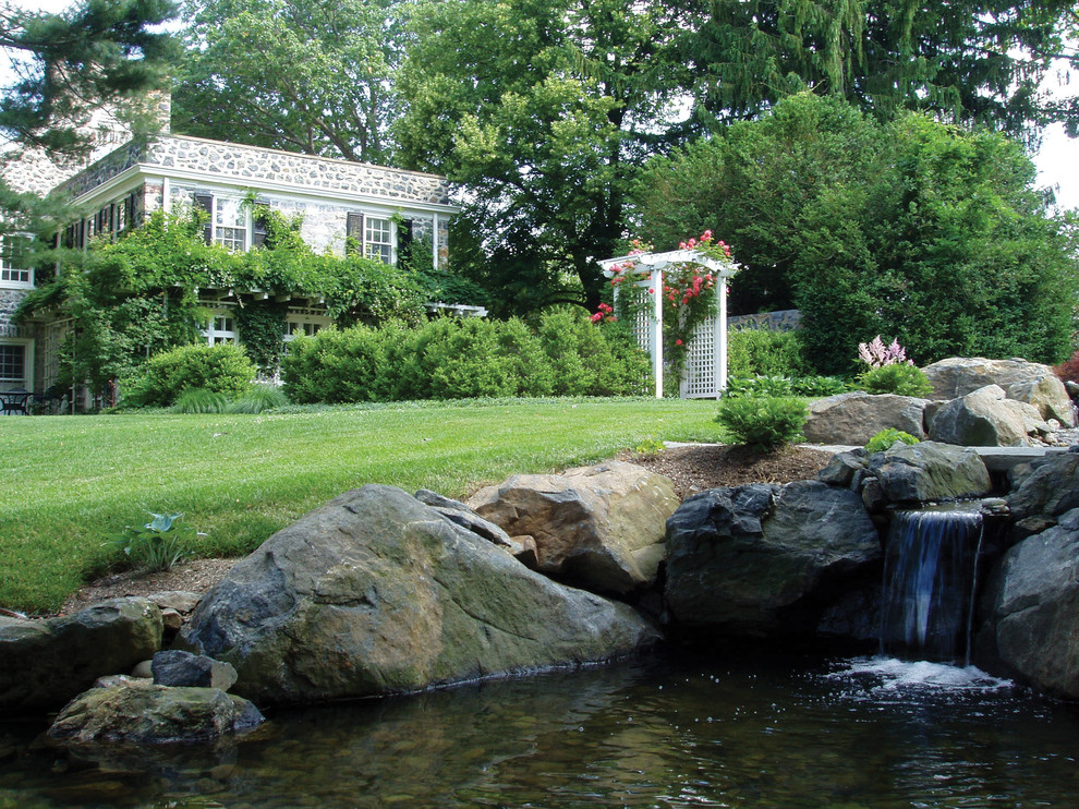 Exemple d'un jardin chic de taille moyenne avec un point d'eau, une exposition partiellement ombragée et des pavés en pierre naturelle.