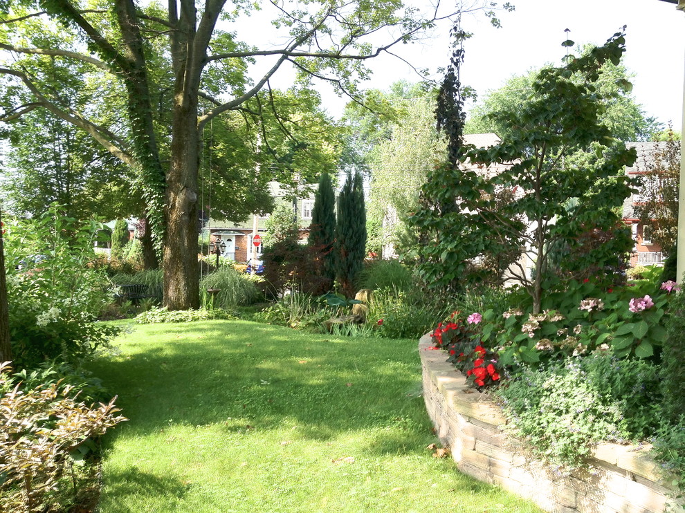 Mittelgroßer, Halbschattiger Klassischer Garten im Sommer mit Natursteinplatten in Montreal