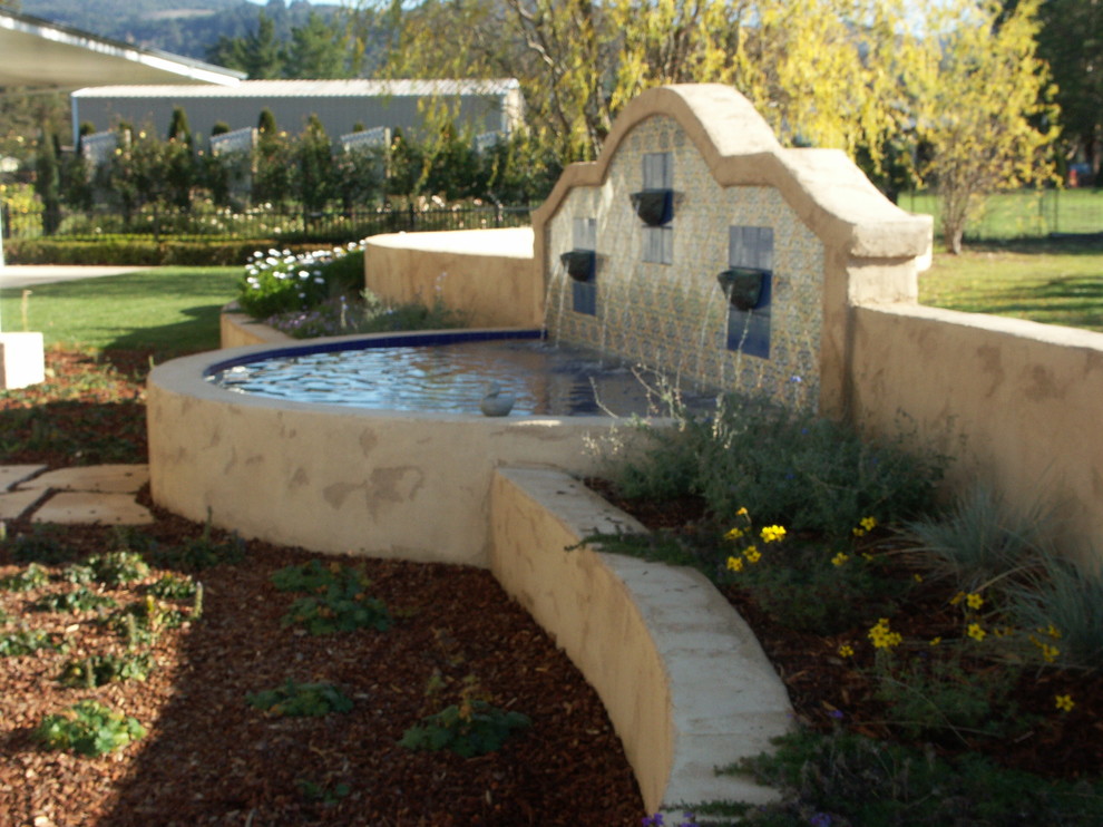 Esempio di un giardino formale mediterraneo esposto a mezz'ombra di medie dimensioni e dietro casa in autunno con fontane