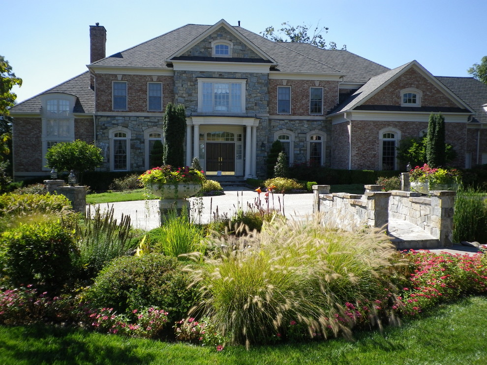 Immagine di un ampio giardino formale classico esposto in pieno sole davanti casa con fontane e pavimentazioni in pietra naturale
