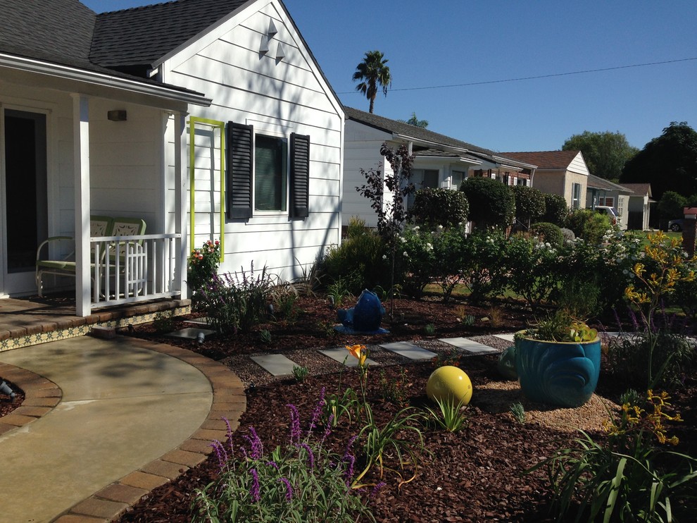 Стильный дизайн: маленький солнечный участок и сад на переднем дворе в стиле фьюжн с растениями в контейнерах, хорошей освещенностью и мощением тротуарной плиткой для на участке и в саду - последний тренд