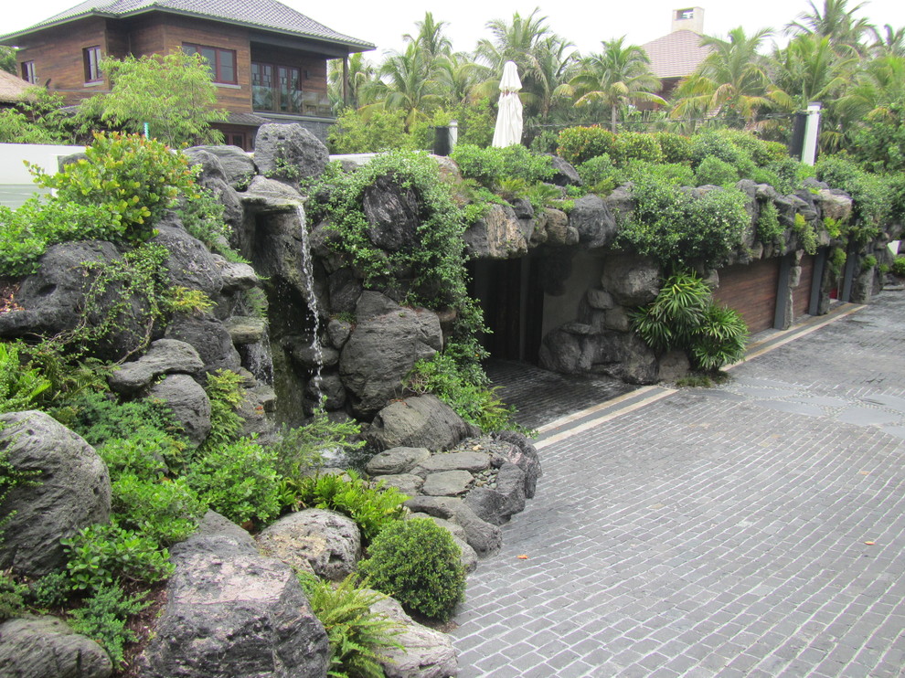 Стильный дизайн: садовый фонтан среднего размера на переднем дворе в восточном стиле с подъездной дорогой и покрытием из каменной брусчатки - последний тренд