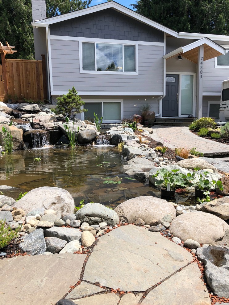 Inspiration for a large world-inspired front full sun garden for summer in Seattle with a pond and natural stone paving.