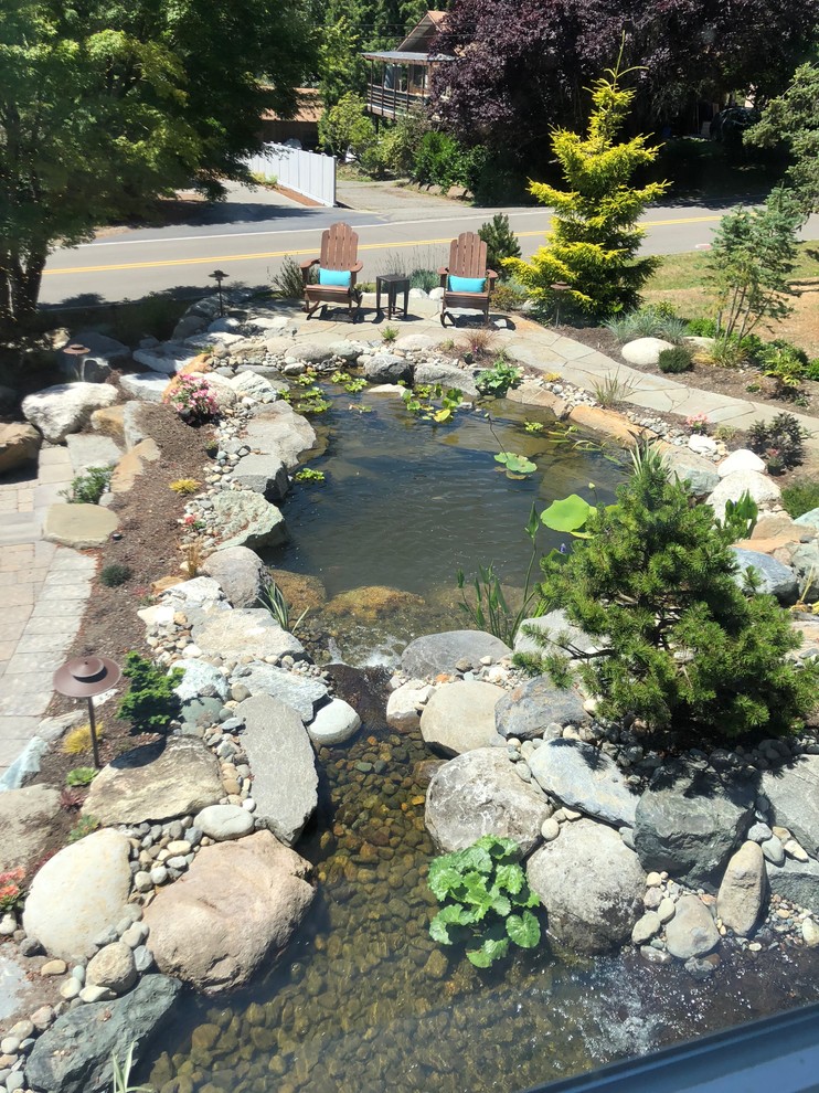 Idee per un grande laghetto da giardino etnico esposto in pieno sole davanti casa in estate con pavimentazioni in pietra naturale