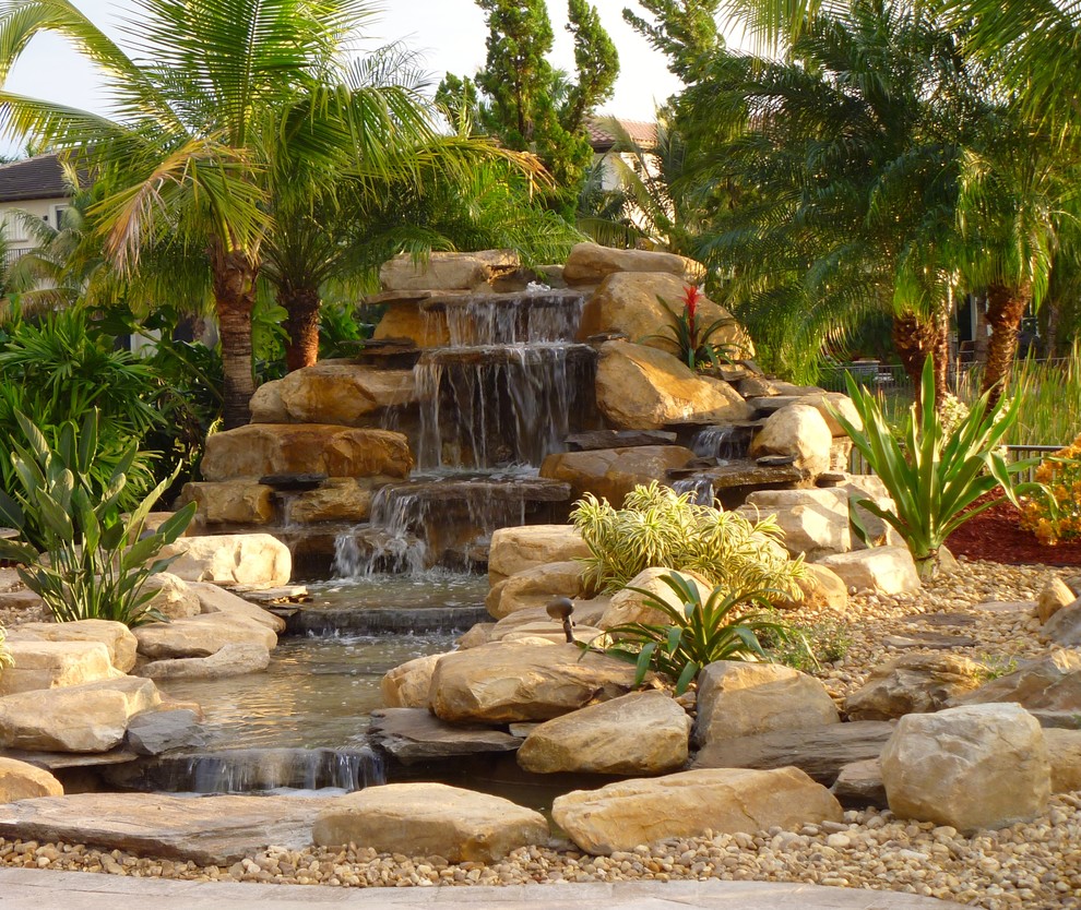 Foto di un giardino tropicale esposto in pieno sole di medie dimensioni e dietro casa con fontane e pavimentazioni in pietra naturale