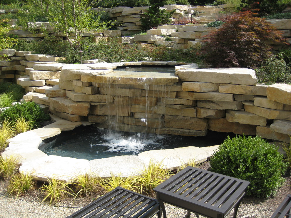 This is an example of a medium sized traditional back garden in Chicago with a water feature and natural stone paving.