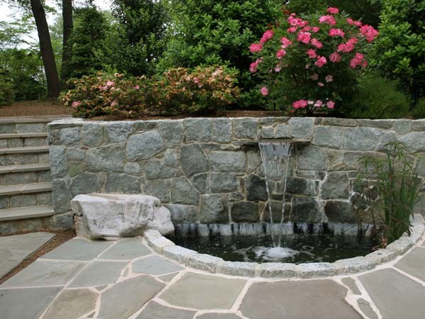 Inspiration pour un jardin arrière minimaliste de taille moyenne avec un point d'eau et des pavés en pierre naturelle.