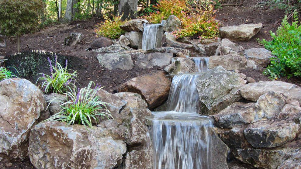 This is an example of a small world-inspired back garden in New York with a water feature.