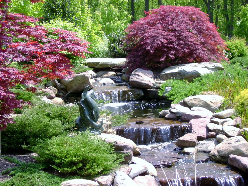 Design ideas for a large classic back formal full sun garden for summer in Baltimore with a pond and gravel.