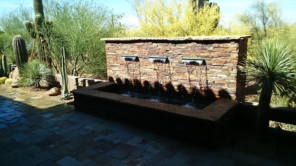 Foto de jardín moderno grande en patio trasero con fuente, exposición total al sol y adoquines de piedra natural