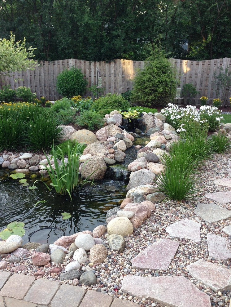 Пример оригинального дизайна: сад с прудом на заднем дворе в классическом стиле