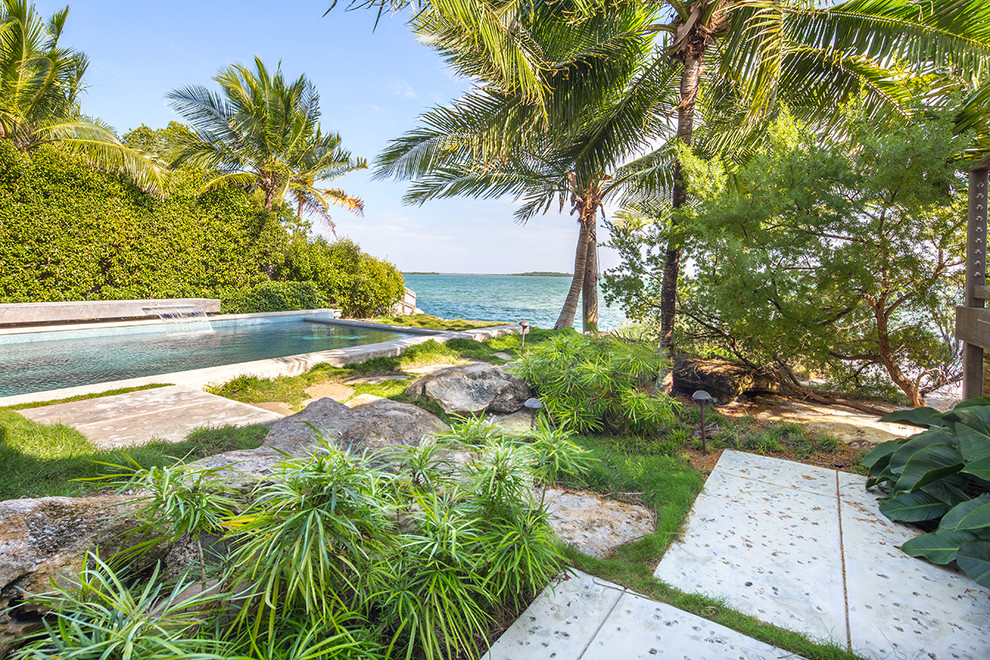 Ispirazione per un grande giardino tropicale esposto in pieno sole dietro casa con pavimentazioni in cemento