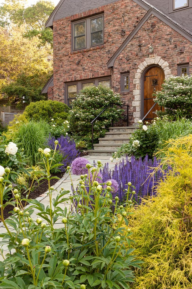 На фото: солнечный участок и сад на переднем дворе в классическом стиле с хорошей освещенностью и мощением тротуарной плиткой с